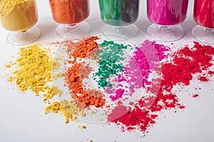Colorful holi powder in glass isolated on white background. Holi festival concept