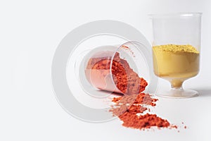 Colorful holi powder in measuring cups on a white background