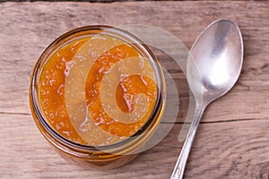 Colorful homemade orange jam in glass jar with