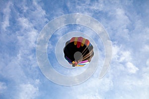 Colorful hot air balloon floating in a white and blue sky in central Wisconsin with copy space