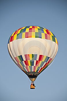 Colorful hot air balloon flying against the blue morning sky