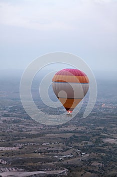 Colorful Hot Air Balloon Flying In Foggy Sky Above Fields