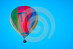 Colorful hot air balloon with the inscription TV against a blue sky