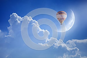 Colorful hot air balloon rise up into blue sky above white cloud photo