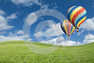 Colorful Hot Air Balloons In Beautiful Blue Sky Above Grass Field