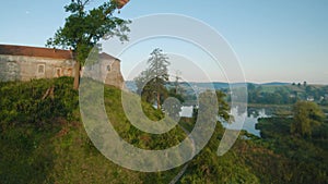 Colorful hot air balloons fly over the medieval castle and lake in the morning fog. Maneuverable flight. Travel