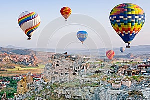 Colorful hot air balloons flying over Cavusin at Cappadocia