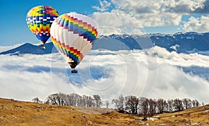 Colorful hot-air balloons flying over the mountain.Artistic pict