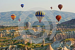 Colorful hot air balloons flying over the valley at Cappadocia photo