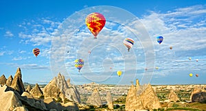 Colorful hot air balloons flying over volcanic cliffs at Cappadocia, Anatolia, Turkey. Panorama photo