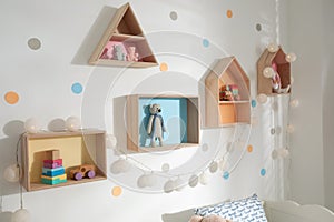 Colorful house shaped shelves on white wall. Children`s room interior design