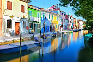 Colorful houses along a canal embankment on Burano island