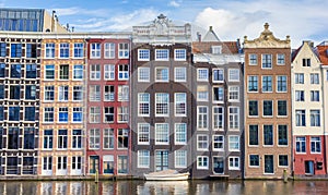 Colorful houses and boat at the Damrak in Amsterdam