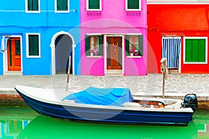 Colorful houses on the canal with boat in Burano island, Venice, Italy