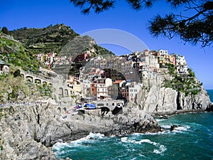 Colorful houses on cliff, Manarola, blue sea