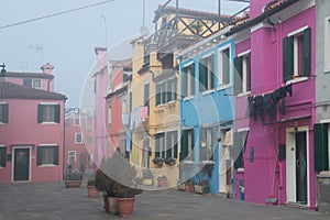Colorful houses on the Italian island Burano, province of Venice, Italy. Multicolored buildings in fog