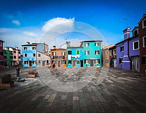 Colorful houses on a small traditional square at Burano island, Venice, Italy