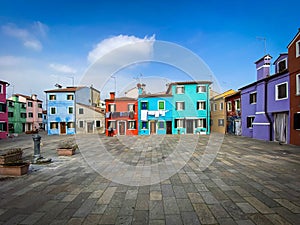 Colorful houses on a small traditional square at Burano island, Venice, Italy