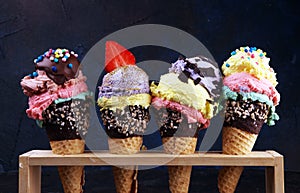 Colorful ice cream cone, rainbow jimmies, chocolate and strawberry toppings floating. Colorful ice cream photo