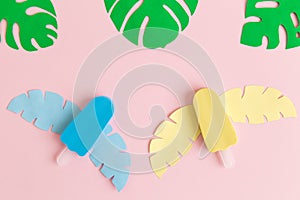 Colorful ice cream and monstera tropical leaves isolated on pastel pink background abstract