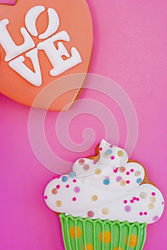 Colorful icing cookie in cupcake shape on pink background