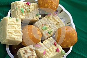 Colorful Indian Diwali sweets in a plain silver dish