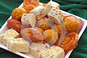 Colorful Indian Diwali sweets in a plain white dish