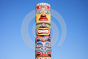 colorful indigenous totem pole against clear sky