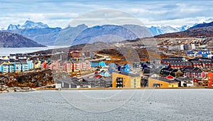 Colorful Inuit buildings in residential district of Nuuk city with lake in the foreground