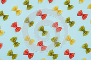 Colorful Italian pasta farfalle or bows on blue background,