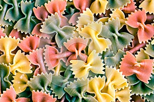 Colorful italian pasta farfalle tricolore abstract background.