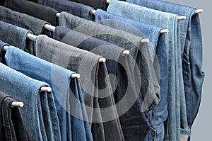 Colorful jeans hanging on hangers