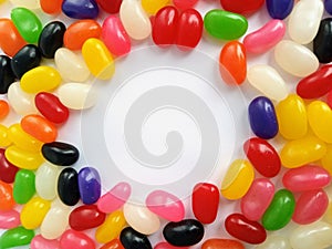 Colorful jelly beans candy border on a white background