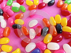 Colorful  jelly beans candy  up close on a pink  background