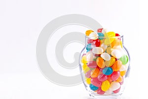 Colorful jelly beans in a small jar isolated on a white background