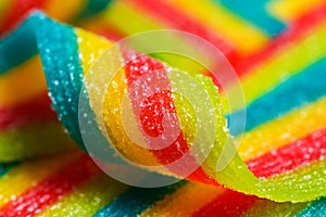 Colorful jelly candies strips in sugar sprinkles. Sour flavored rainbow candy background