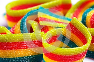 Colorful jelly candies strips in sugar sprinkles. Sour flavored rainbow candy background