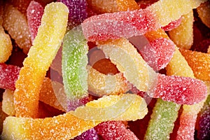 Colorful jelly marmalade worms, sweet delicious background. Light sweet dessert. Macro photo.