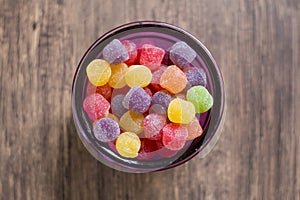 Colorful jujubes in glass bowl top view