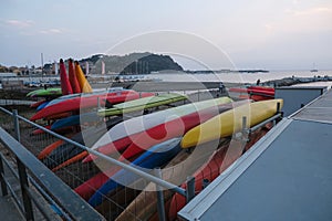 colorful kayak on the beach across coastline and sunset sea in Sestre Levante, Liguria, Italy. Sea sport, active lifestyle