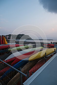 colorful kayak on the beach across coastline and sunset sea in Sestre Levante, Liguria, Italy. Sea sport, active lifestyle