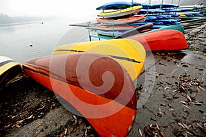 Colorful Kayaks and canoes in a Row stack