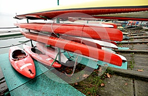 Colorful Kayaks and canoes in a Row stack