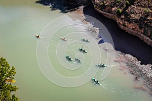 Colorful kayaks floating in green river under the cliff in the Parque Natural de las Hoces del RiÂ­o Duraton, Spain.