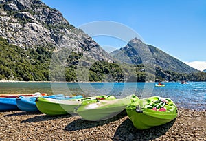 Colorful Kayaks in a lake surrounded by mountains at Bahia Lopez in Circuito Chico - Bariloche, Patagonia, Argentina photo