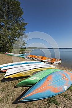 Colorful kayaks moored on lakeshore, Goldopiwo Lake, Mazury, Pol