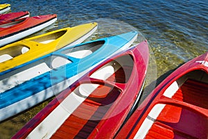 Colorful kayaks moored on lakeshore, Goldopiwo Lake, Mazury, Pol photo