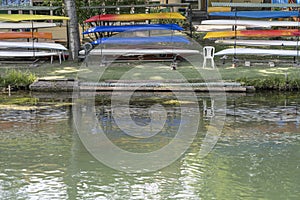 colorful kayaks on racks at river Sile embankment, Treviso, Italy