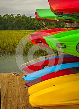 Colorful kayaks stacked up on a rack on wharf at Hilton Head Island dock on water