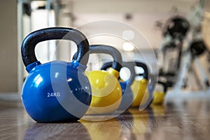 Colorful kettlebells in a row in a gym, blue and yellow color